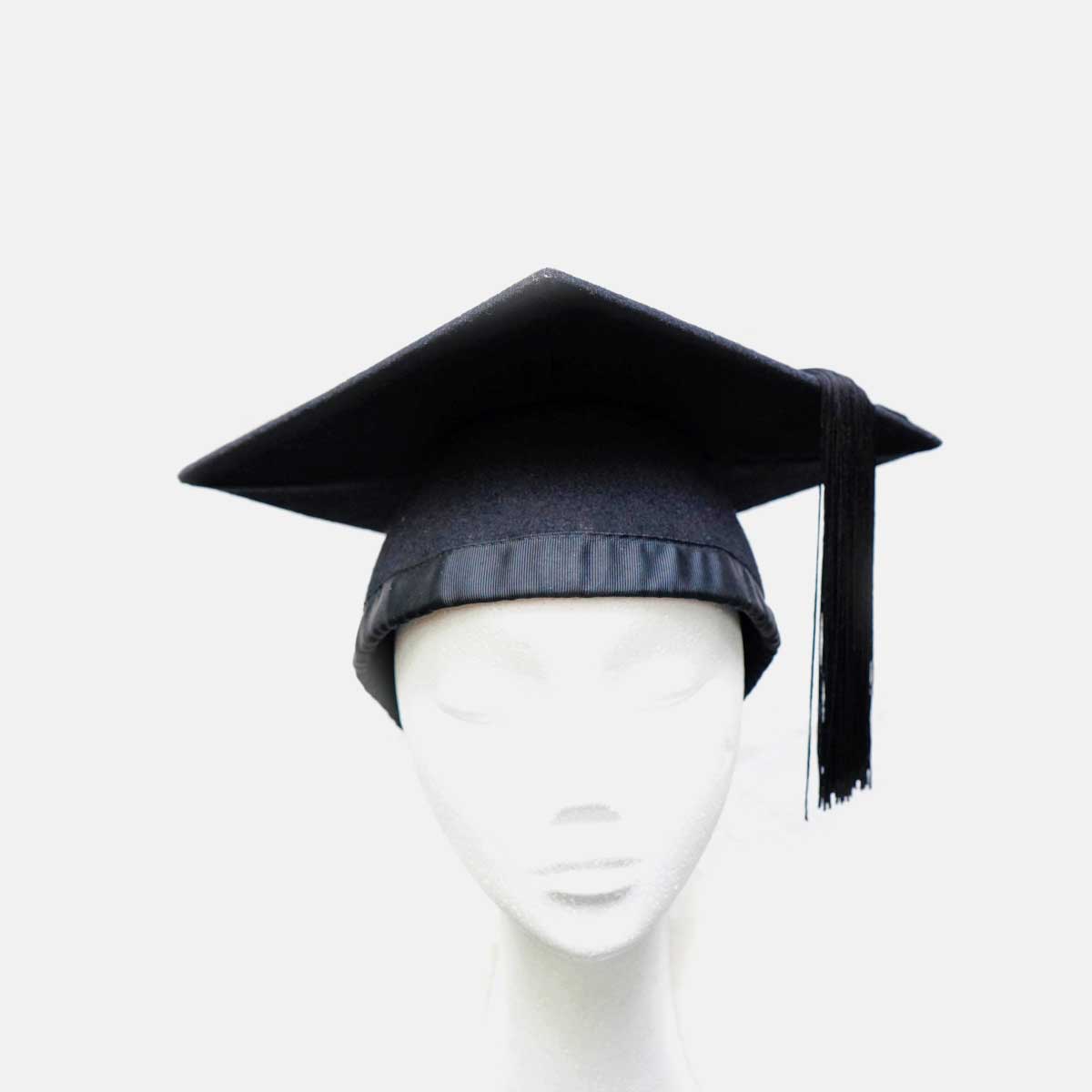 Woman adjusting her graduation gown and mortarboard in campus Stock Photo  by leungchopan
